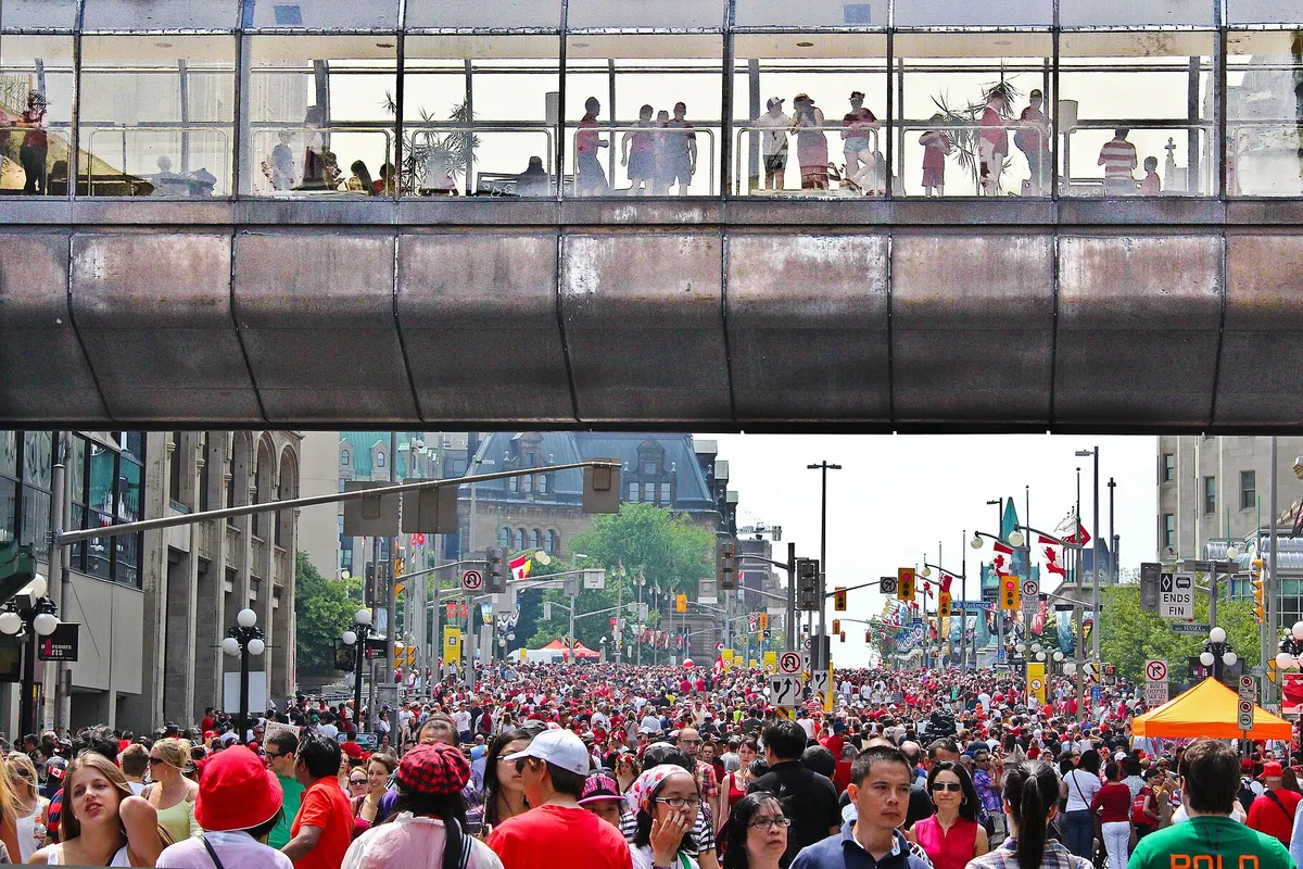 Crowds dressed in red and white filling a downtown Ottawa street on Canada Day